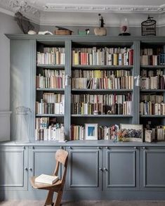 a chair sitting in front of a book shelf filled with books