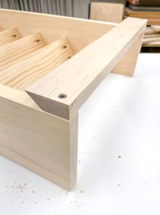 a wooden box is sitting on the table with some woodworking tools in front of it