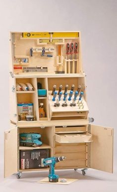 a wooden tool box with tools in it on top of a white table next to a pair of drillers