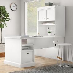 a white desk with two stools next to it and a clock on the wall