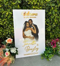 a welcome sign with flowers and greenery in the background for a newly married couple