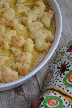 a close up of a bowl of food on a table with an oven mitt