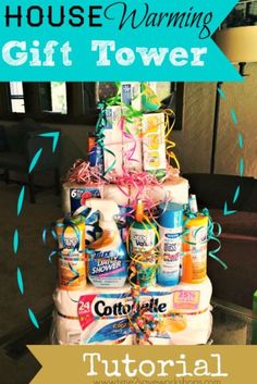 a stack of toilet paper wrapped in pink and blue ribbon with the words house warming gift tower