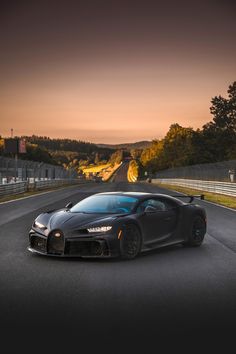 a bugatti on the road at sunset