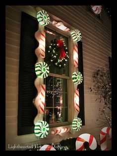 lighted candy cane wreath in front of a window with christmas decorations on the windowsill