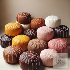 a pile of different colored poufles sitting next to each other on a table