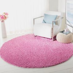 a white chair and pink rug in a room