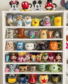 a shelf filled with lots of disney figurines on top of it's shelves