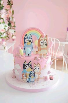 a pink cake with cartoon characters on it