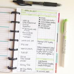 an open planner and pen on top of a white table