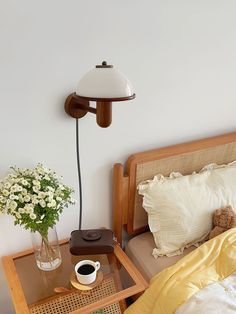 a bed room with a neatly made bed and a lamp on the wall above it