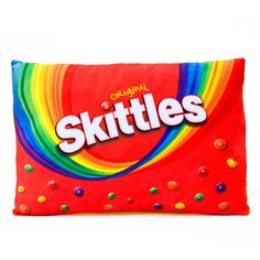 skittles candy bar on a red pillow with rainbow swirls in the background