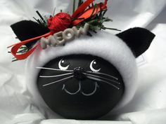 a black and white cat ornament with the word mom on it's face