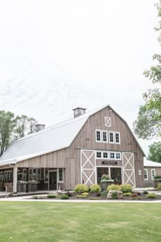 a large barn with a white roof and two story windows on the side of it