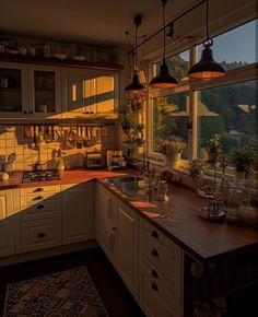 a kitchen filled with lots of counter top space next to a window covered in sunlight