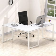 an office desk with a computer and chair in front of a clock on the wall