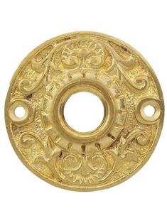 an antique brass plate with ornate designs on it's side and two holes in the middle