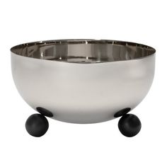 a large metal bowl with two black balls on the bottom and one white ball in the middle