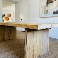 a large wooden table sitting in the middle of a living room next to a doorway