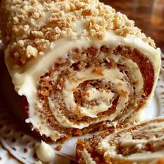 a close up of a pastry on a plate with white frosting and cinnamon rolls