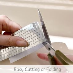 a person cutting paper with scissors on a table