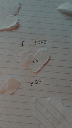 i love you written on lined paper with torn up pieces of paper next to it