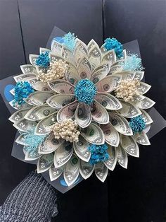 a bouquet made out of dollar bills and blue flowers