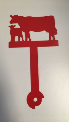 a red metal clock with cows on it