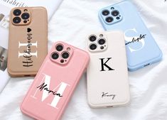 three iphone cases with the letter m and k on them, sitting next to each other