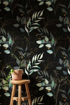 the wallpaper is black with green leaves on it and a stool next to it