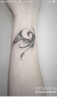 a black and white photo of a dragon tattoo on the left side of the arm