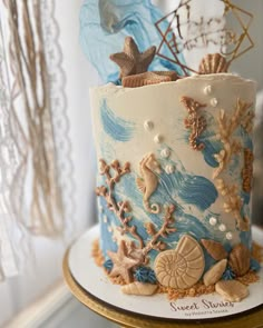 there is a blue and white cake with shells on it