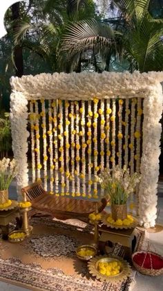 an outdoor ceremony setup with flowers and candles on the table, along with other decorations