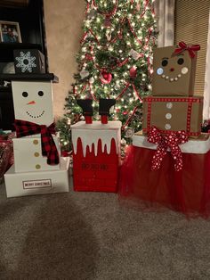 christmas presents are sitting in front of a tree and decorated with snowman, gingerbread man