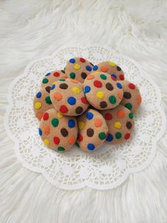 some cookies are sitting on a doily with multicolored polka dot dots in the middle