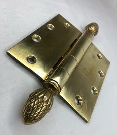 an antique brass door hinge with pineapple knobs