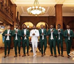 a group of men in green suits posing for a photo