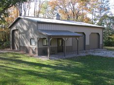 a garage in the middle of a field with lots of grass and trees around it