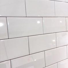 a white tiled wall in a public restroom