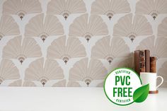 a coffee cup sitting on top of a white counter next to a wallpapered background