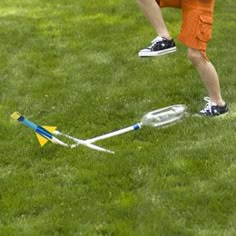 a young boy is playing with his toy rocket on the grass