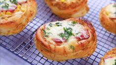 several mini pizzas on a cooling rack with cheese and herbs in the middle, ready to be eaten