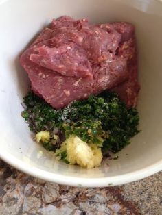 meat, broccoli and cauliflower in a white bowl on the counter