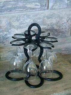 four wine glasses sitting on top of each other in front of a stone wall,