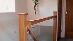 an empty room with some plants hanging on the wall and a glass door leading to another room