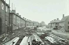 an old black and white photo of construction on the street in front of brick buildings