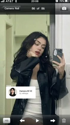 a woman taking a selfie with her cell phone in front of her face and wearing a black leather jacket