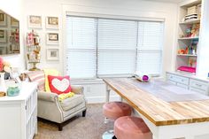 a living room filled with furniture and a wooden table in front of a window on top of a hard wood floor