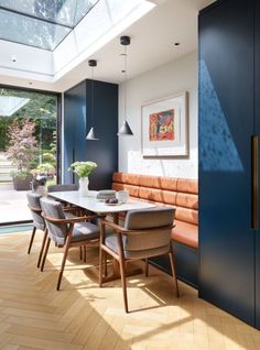 a dining room with blue walls and wooden flooring next to a large glass door