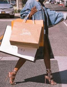 a woman is walking down the street with shopping bags in her hand and shoes on